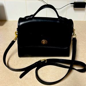 Black Coach shoulder or hand bag.  Has a zip compartment inside.  Outside pocket